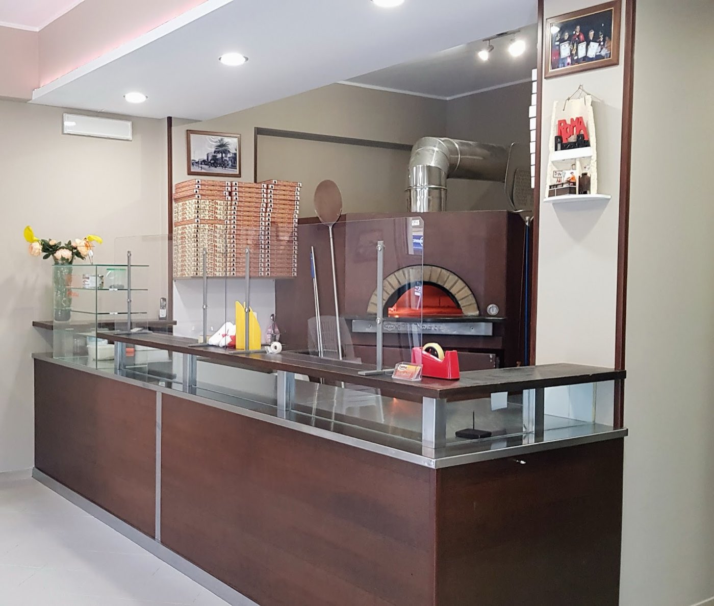 Il forno a legna acceso con i cartoni della pizza Roma pronti per l’asporto