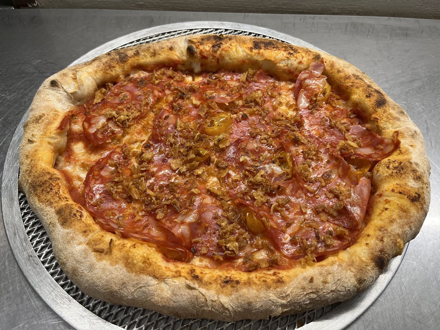 Pizza con salame piccante e pomodorini appena sfornata